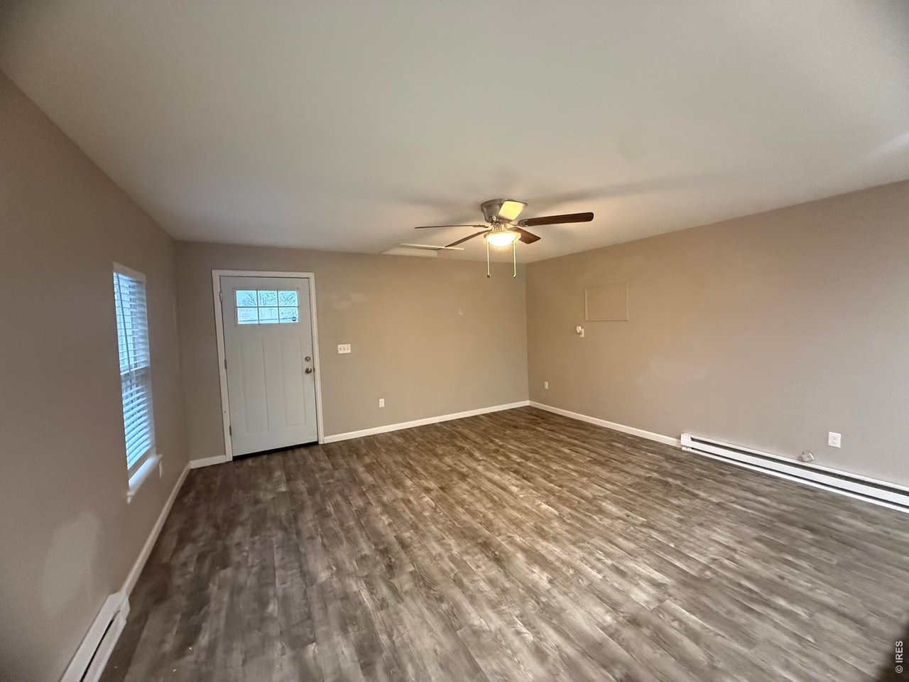 703 North 2nd Street Sterling, CO 80751 - Photo 2 of 19 a view of an empty room with wooden floor and window