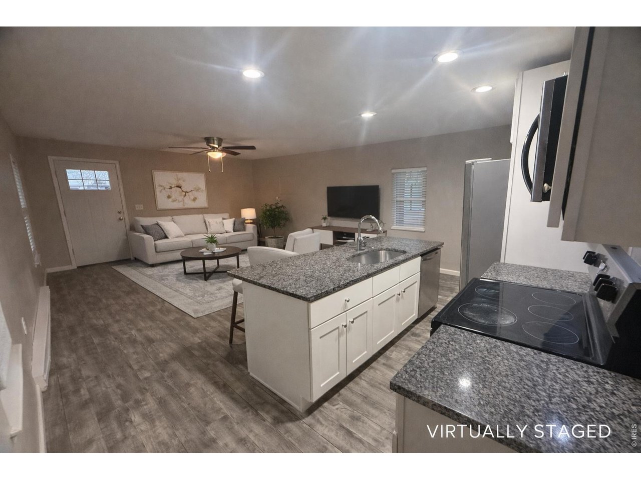 703 North 2nd Street Sterling, CO 80751 - Photo 4 of 19 a living room with stainless steel appliances kitchen island granite countertop furniture a rug and a window