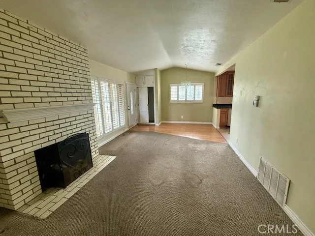 a view of a livingroom with an empty space and a fireplace