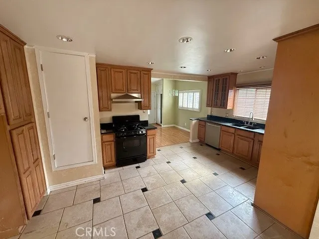 a kitchen with granite countertop a refrigerator and a stove top oven