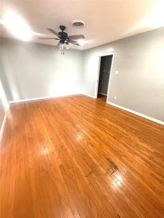 a view of a big room with wooden floor and a ceiling fan
