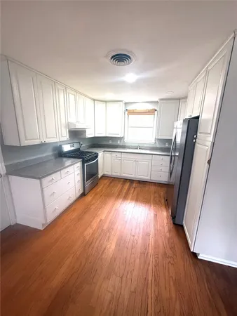 a kitchen with stainless steel appliances granite countertop wooden floors and white counter top
