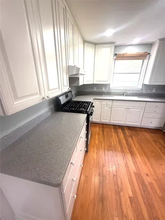 a kitchen with wooden floors and a window