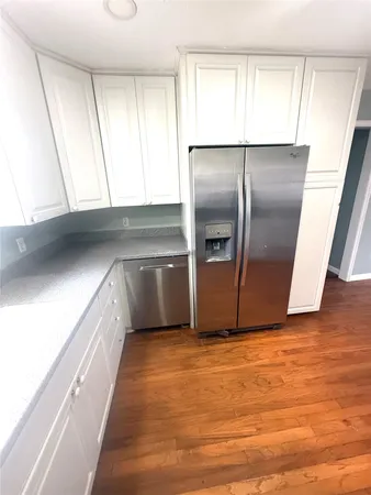 a kitchen with granite countertop a refrigerator and a sink