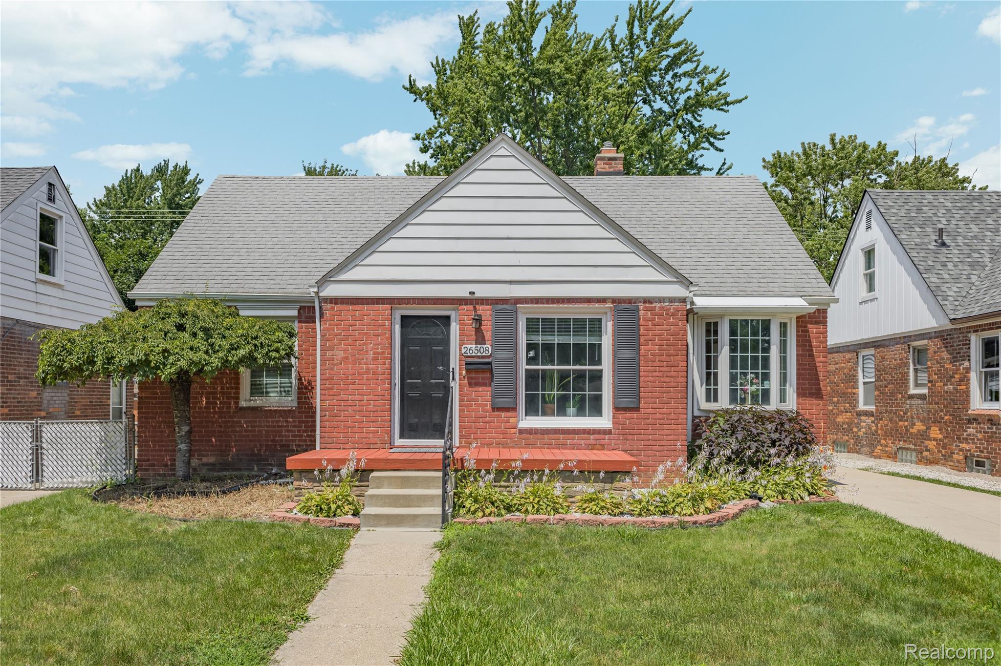 26508 Five Mile Road Redford, MI 48239 - Photo 2 of 41 Brick facade residence featuring a front gabled roofline with horizontal siding, a bay window, and a dark front door