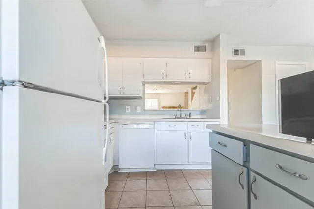 a kitchen with white cabinets and white appliances