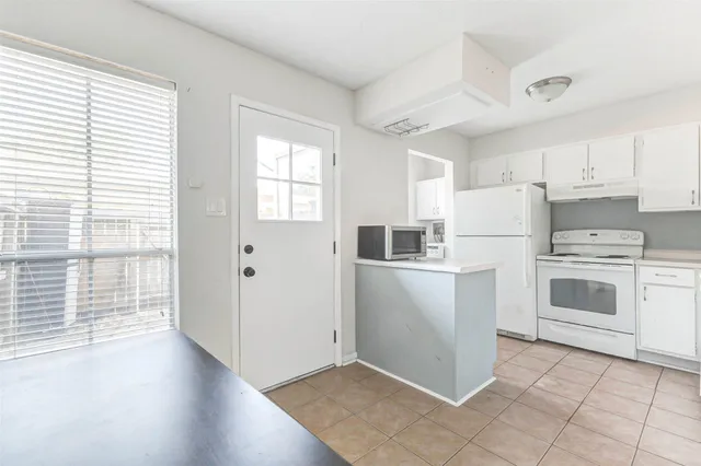 a view of a kitchen with refrigerator and wooden floor
