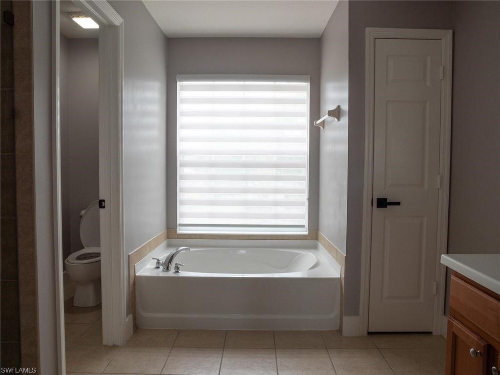 2822 Inlet Cove Lane West Naples, FL 34120 - Photo 12 of 23 a bathroom with bathtub and window