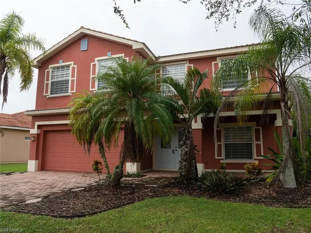 a view of a house with a yard and potted plants