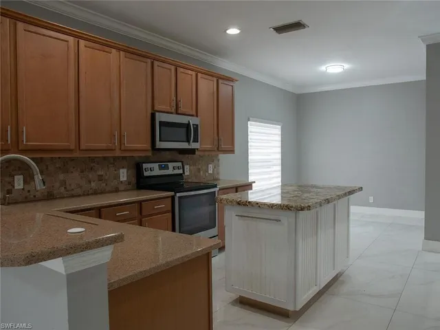 a kitchen with granite countertop stainless steel appliances a stove top oven a sink and dishwasher