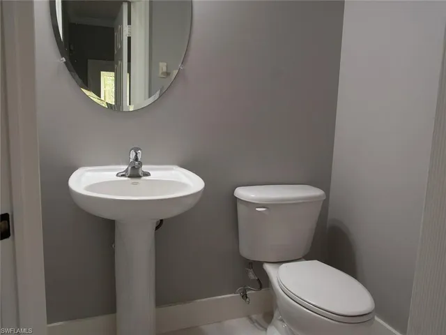 a white toilet sitting next to a bathroom sink