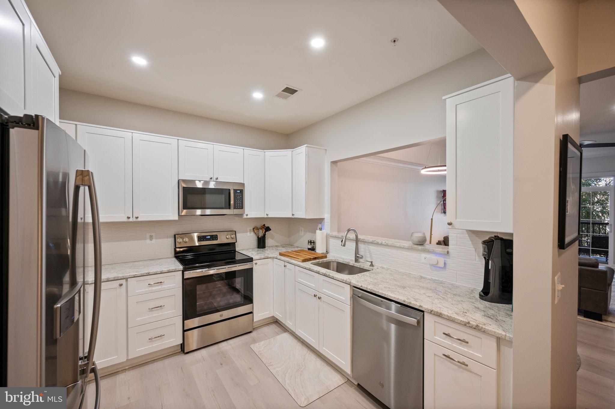 7315 Maplecrest Road, Unit 205 Elkridge, MD 21075 - Photo 4 of 54 a kitchen with white cabinets and stainless steel appliances