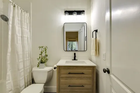 a bathroom with a toilet sink and mirror