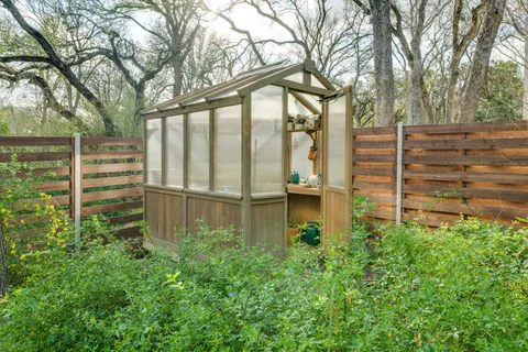 a backyard of a house with lots of green space and fountain