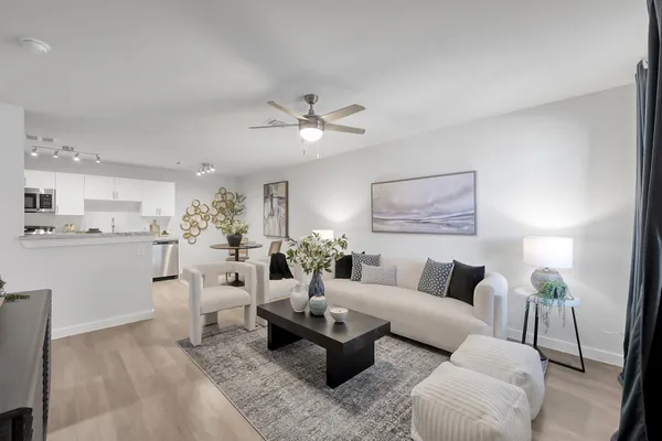 a living room with furniture and view of kitchen