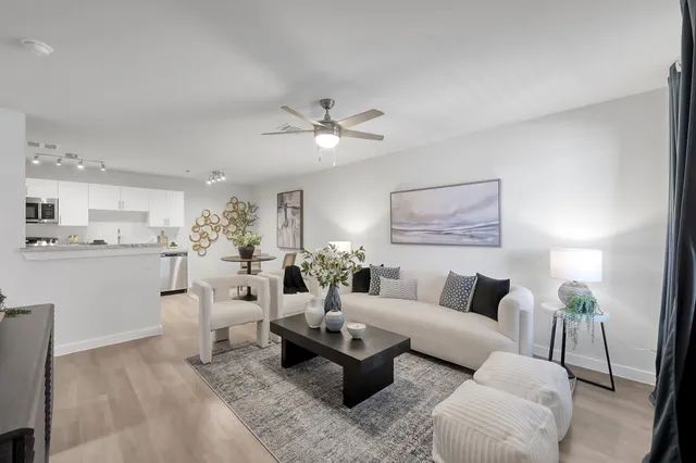 a living room with furniture and view of kitchen
