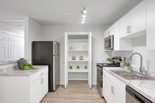 a kitchen with a refrigerator sink and white cabinets