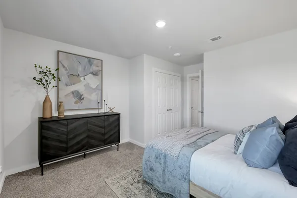 a bedroom with a bed and a painting on the wall