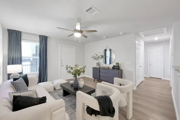 a living room with furniture potted plant and a window