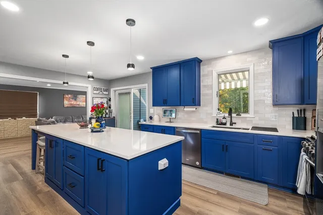 a kitchen with wooden cabinets a sink dishwasher and a stove with wooden floor