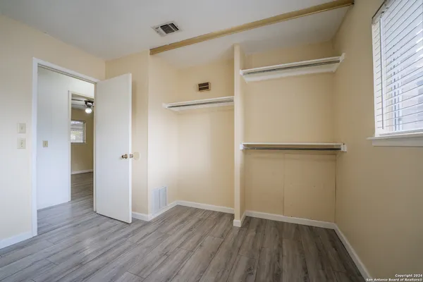an empty room with wooden floor and a window