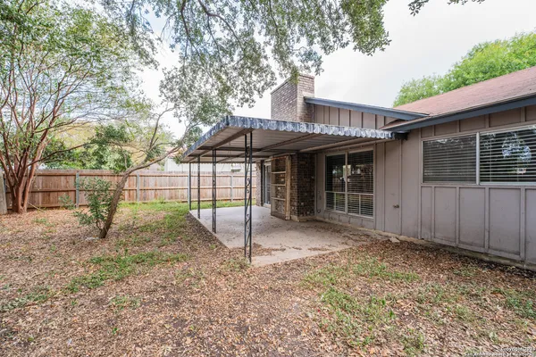 a view of a house with a backyard and a tree