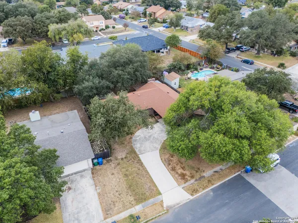 an aerial view of a house with a yard and greenery
