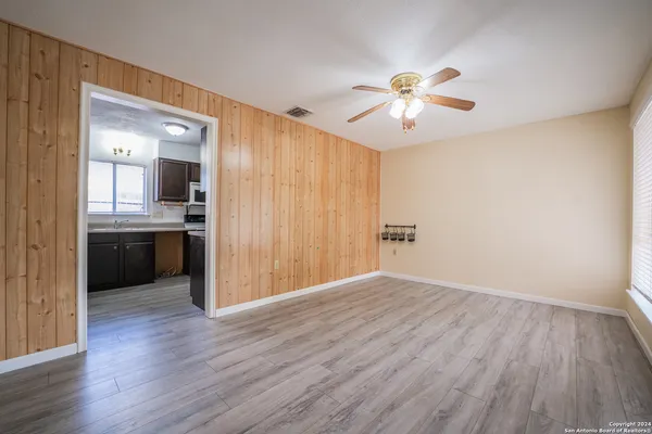 a view of a kitchen with wooden floor and a ceiling fan