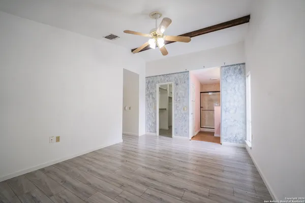 a view of an empty room with wooden floor