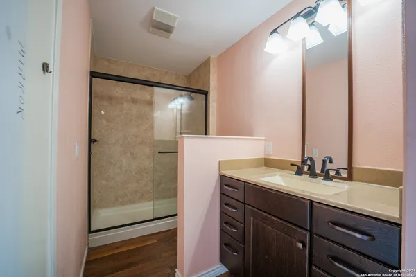 a bathroom with a double vanity sink mirror and shower