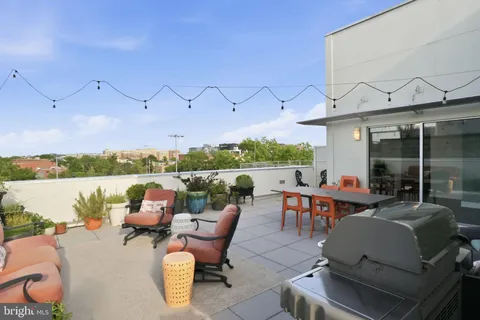 a view of a terrace with furniture and a garden