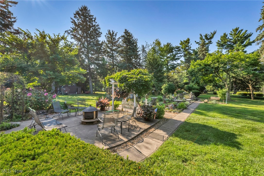 25915 Kennedy Ridge Road North Olmsted, OH 44070 - Photo 39 of 48 View of green lawn featuring a patio, view of scattered trees, and an outdoor fire pit