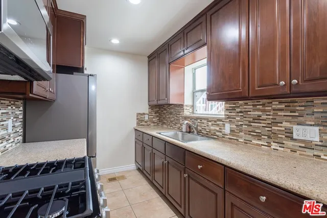 a kitchen with stainless steel appliances granite countertop wooden cabinets a sink and dishwasher