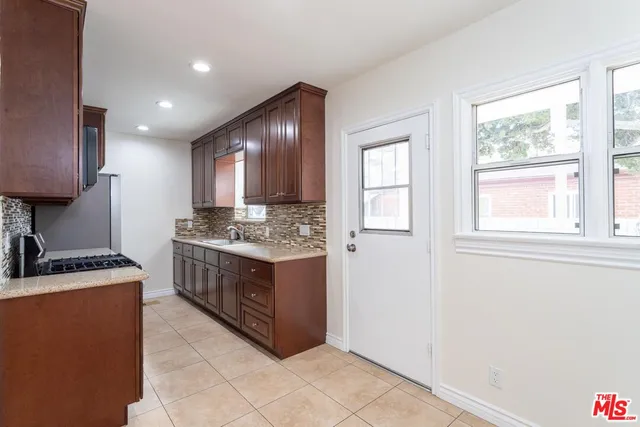 a kitchen with stainless steel appliances granite countertop a stove a sink and a microwave