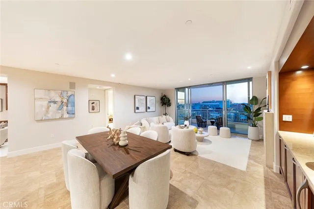 a living room with furniture a table and kitchen view