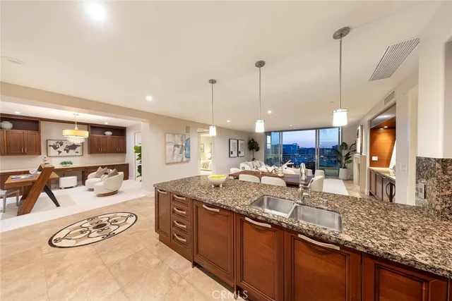 a large kitchen with kitchen island a large counter top space and stainless steel appliances