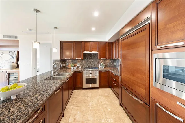 a kitchen with stainless steel appliances granite countertop sink stove refrigerator and cabinets