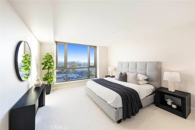 a spacious bedroom with a bed a table and a large window