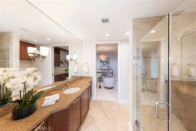 a bathroom with a granite countertop tub and a large mirror