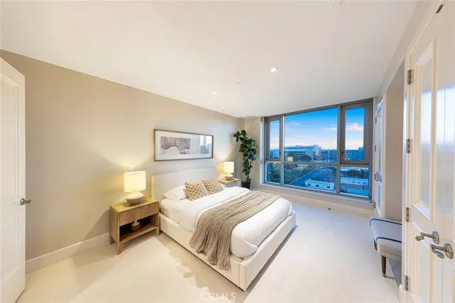 a spacious bedroom with a bed and a large window