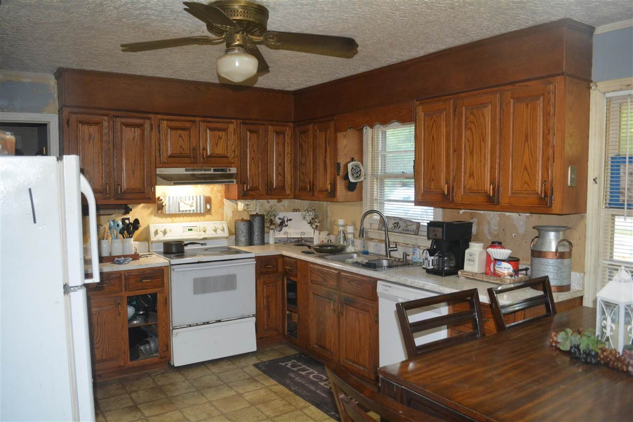 1292 Sweet Lips Road Finger, TN 38334 - Photo 7 of 15 a kitchen with granite countertop wooden cabinets a stove a sink and dishwasher