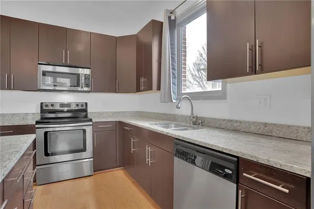 a kitchen with stainless steel appliances granite countertop a sink stove and microwave