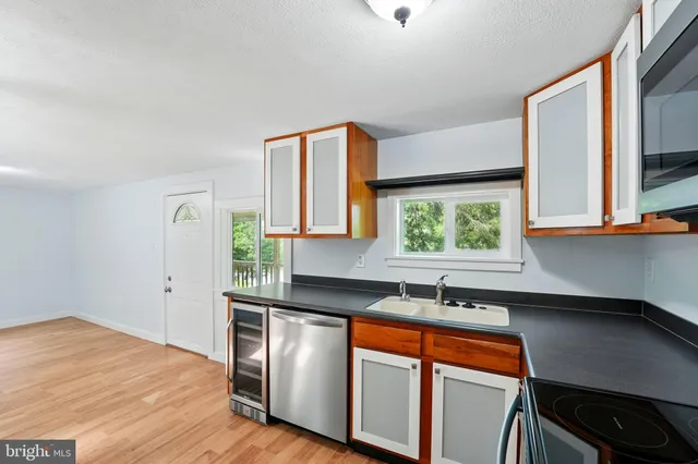 a kitchen with stainless steel appliances granite countertop a sink a stove and a refrigerator