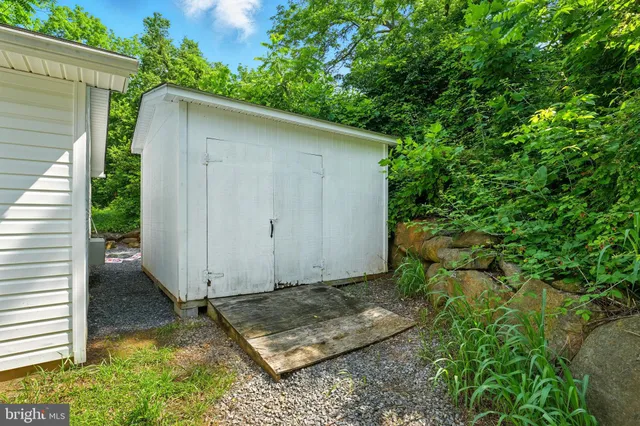 a backyard of a house with plants and wooden fence