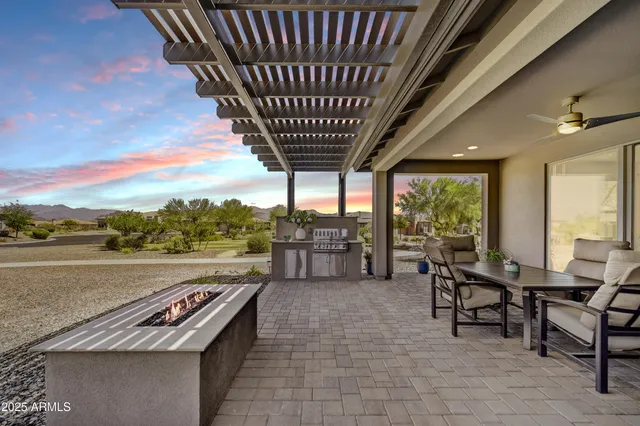 a view of a patio with table and chairs under an umbrella