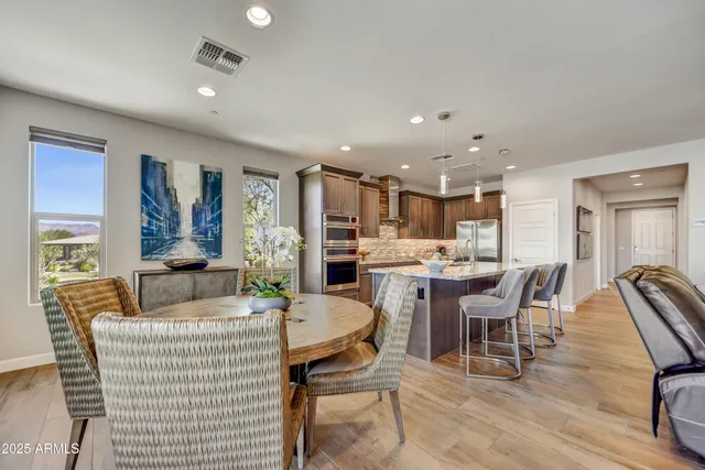 a living room with furniture and a dining table with wooden floor