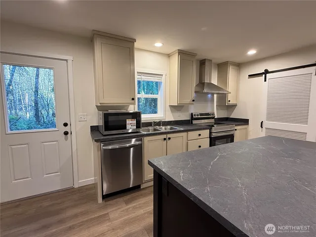 a kitchen with granite countertop a sink cabinets and wooden floor