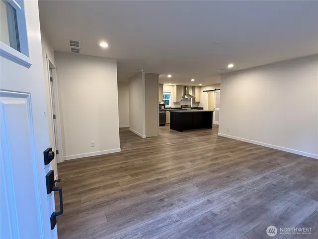 an empty room with wooden floor and furniture