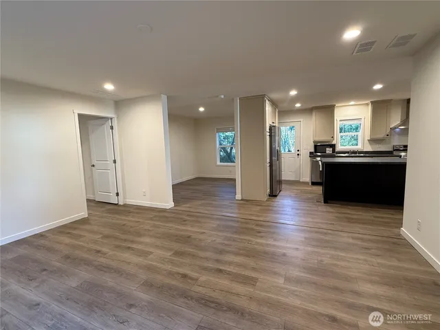a view of a living room a kitchen with wooden floor