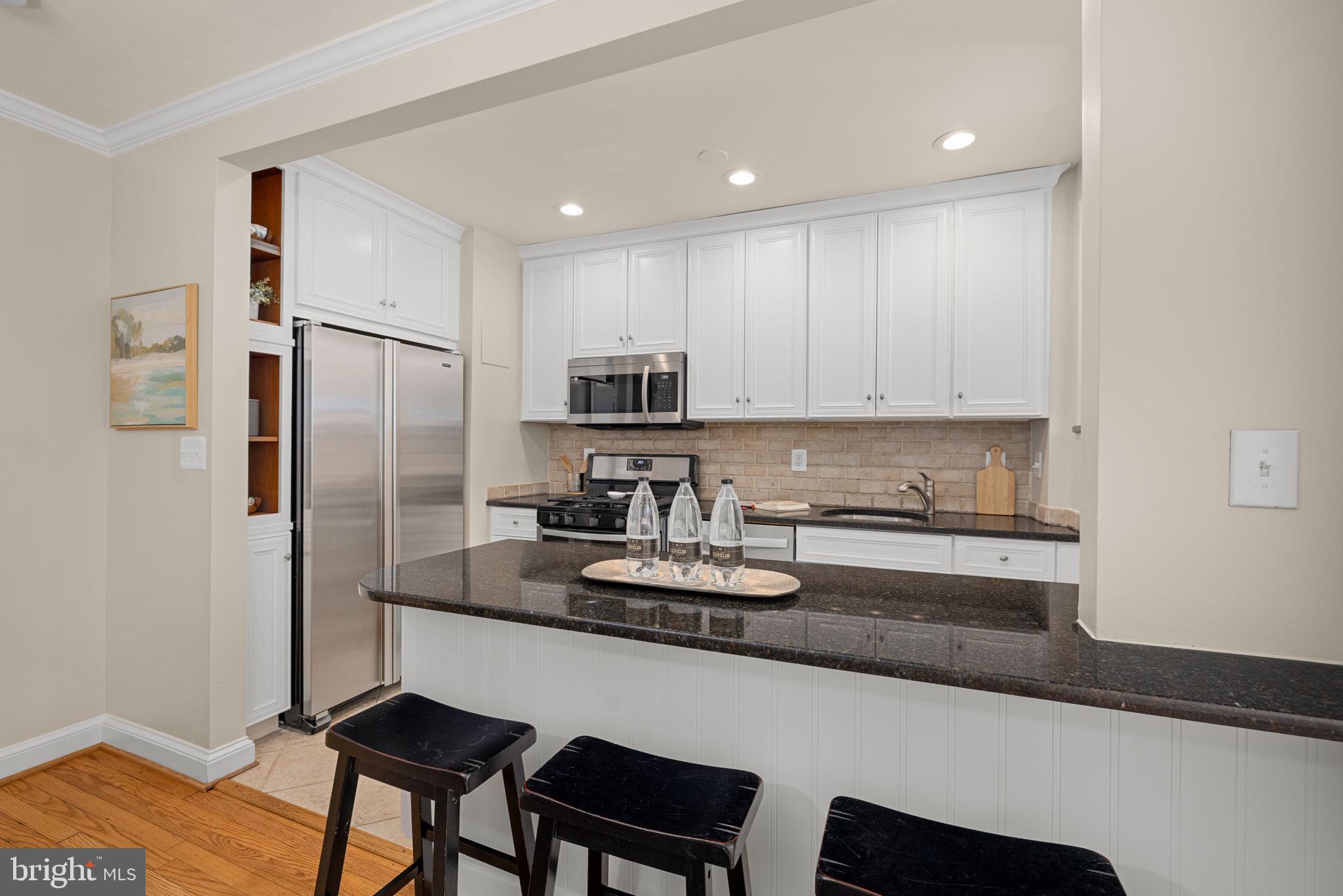 3762 W Street Northwest Washington, DC 20007 - Photo 12 of 41 a kitchen with stainless steel appliances granite countertop a refrigerator and a stove top oven